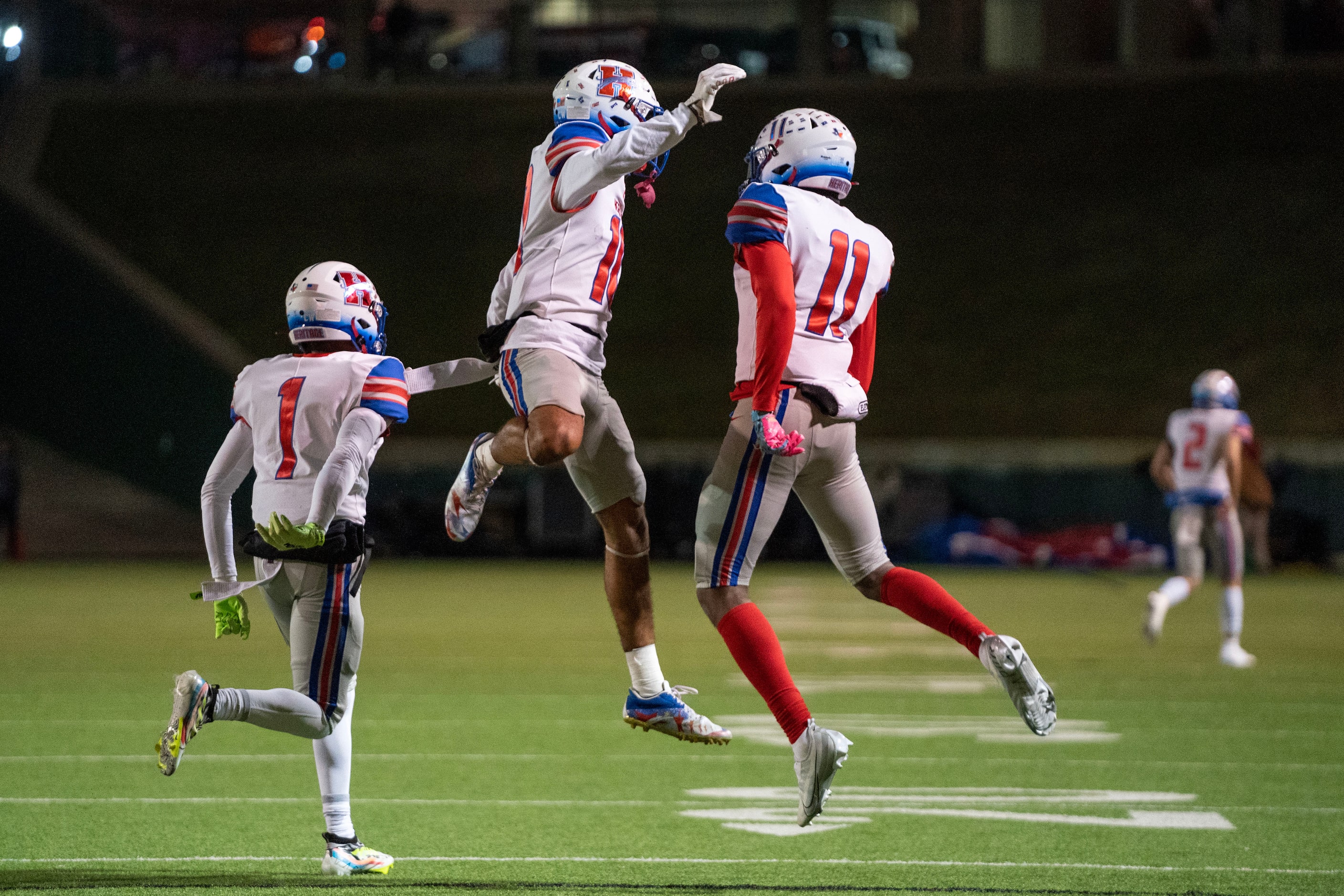 Midlothian Heritage senior wide receivers Tae Jackson (10), center, and Xavier Moten (11)...