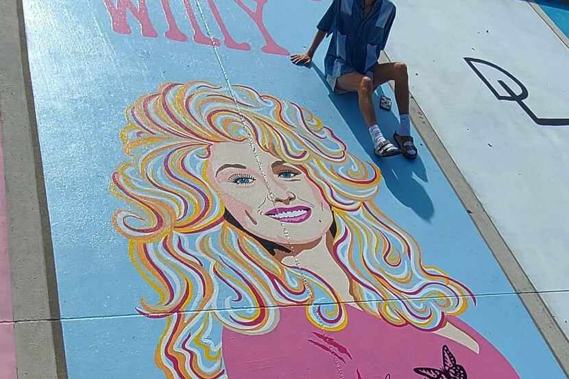Will Lepard poses with his mural of Dolly Parton, which was vandalized at Aledo High School.
