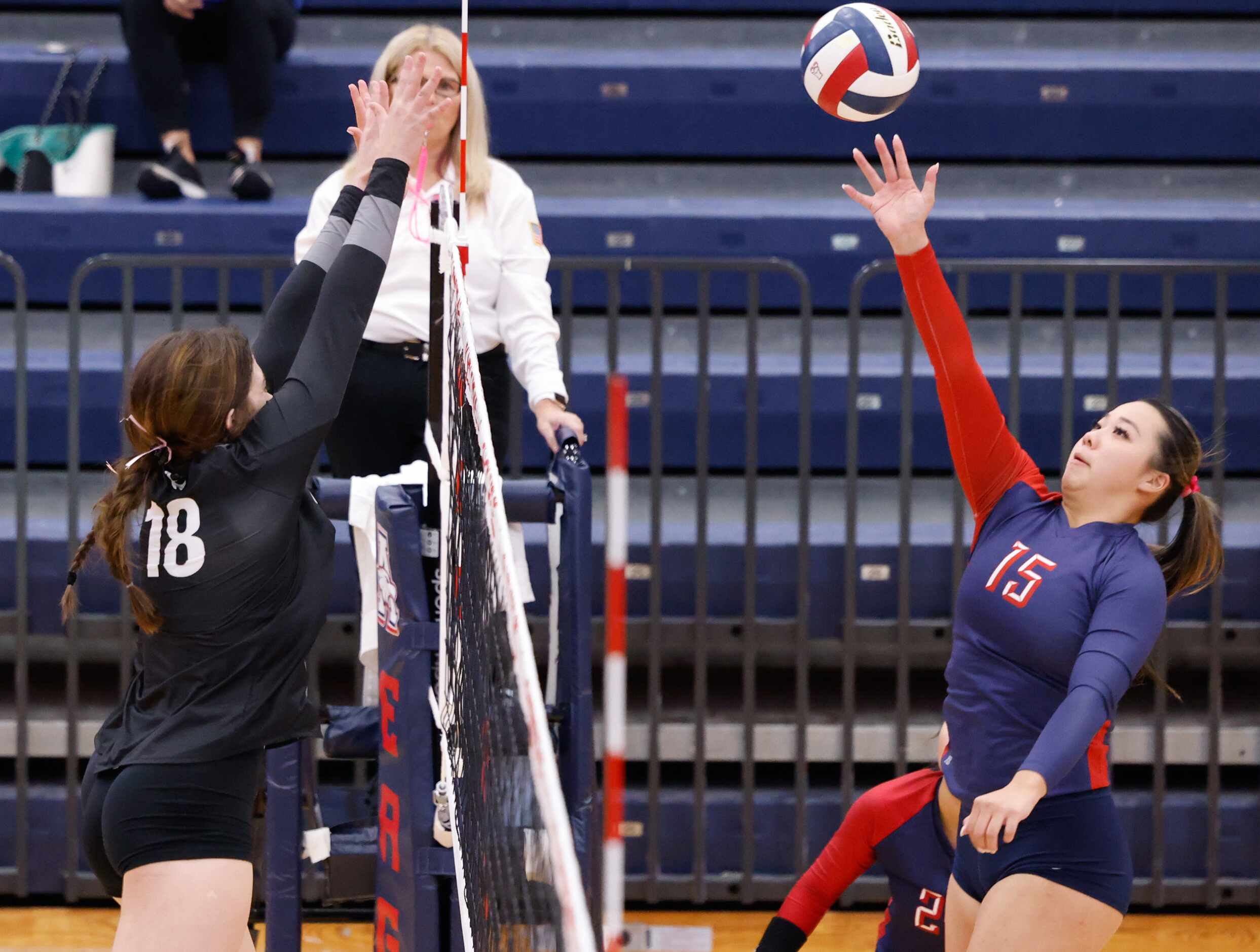 Allen senior Janet Zhang (15) spikes the ball toward Denton Guyer defenders including senior...