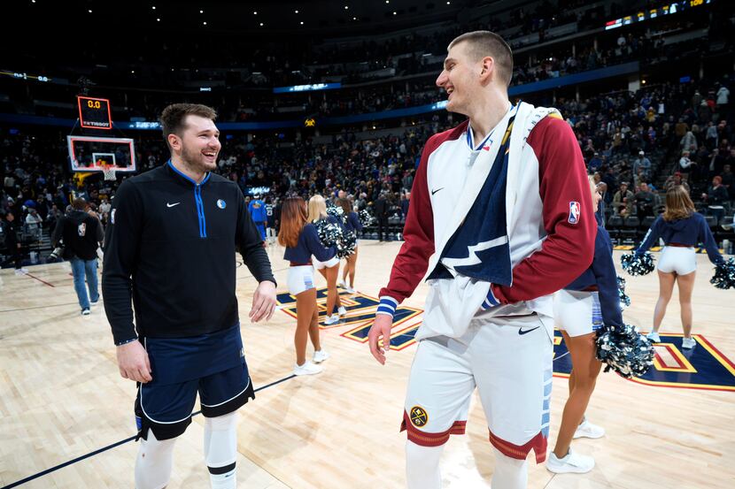 Dallas Mavericks guard Luka Doncic, left, jokes with Denver Nuggets center Nikola Jokic...