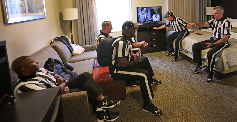 The SEC officiating crew relaxes in a motel room before catching a bus to the stadium before...