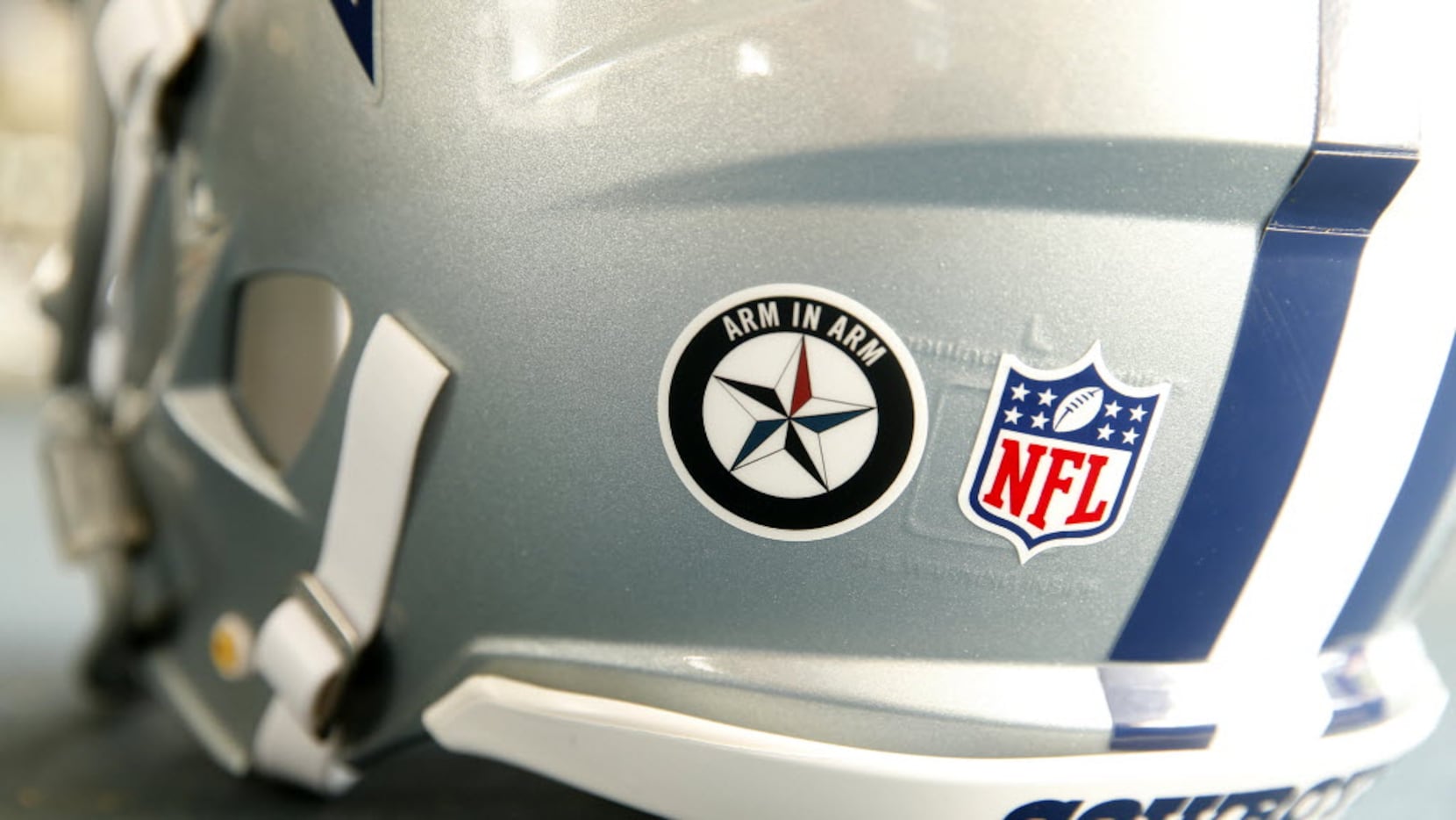 The Dallas Cowboys players are wearing a special Arm-in-Arm decal on their helmets during...