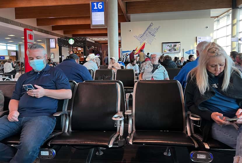 Masked and unmasked Southwest Airlines passengers sat at Gate 16 at Dallas Love Field while...