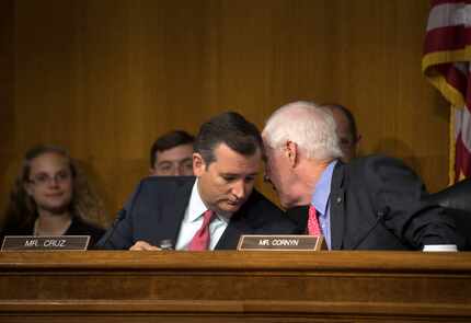 Cruz and Senate colleague John Cornyn confer during a committee hearing. (File Photo/The New...