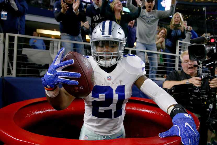Ezekiel Elliott #21 of the Dallas Cowboys celebrates after scoring a touchdown by jumping...