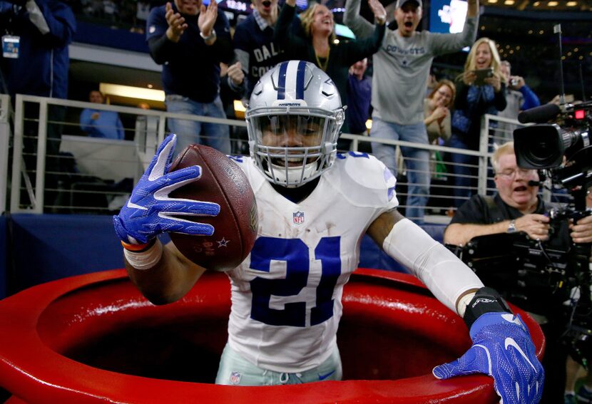 Ezekiel Elliott #21 of the Dallas Cowboys celebrates after scoring a touchdown by jumping...