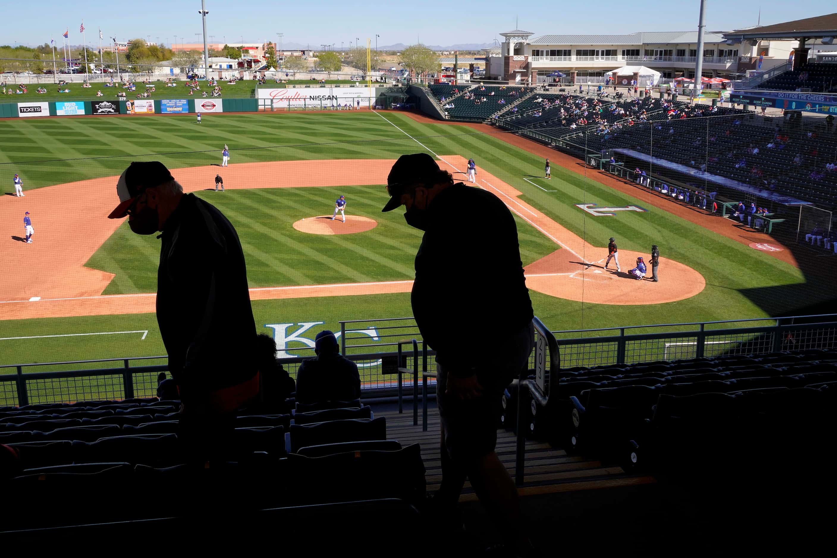 Fans head to their socially distant seating pods during a a spring training game between the...