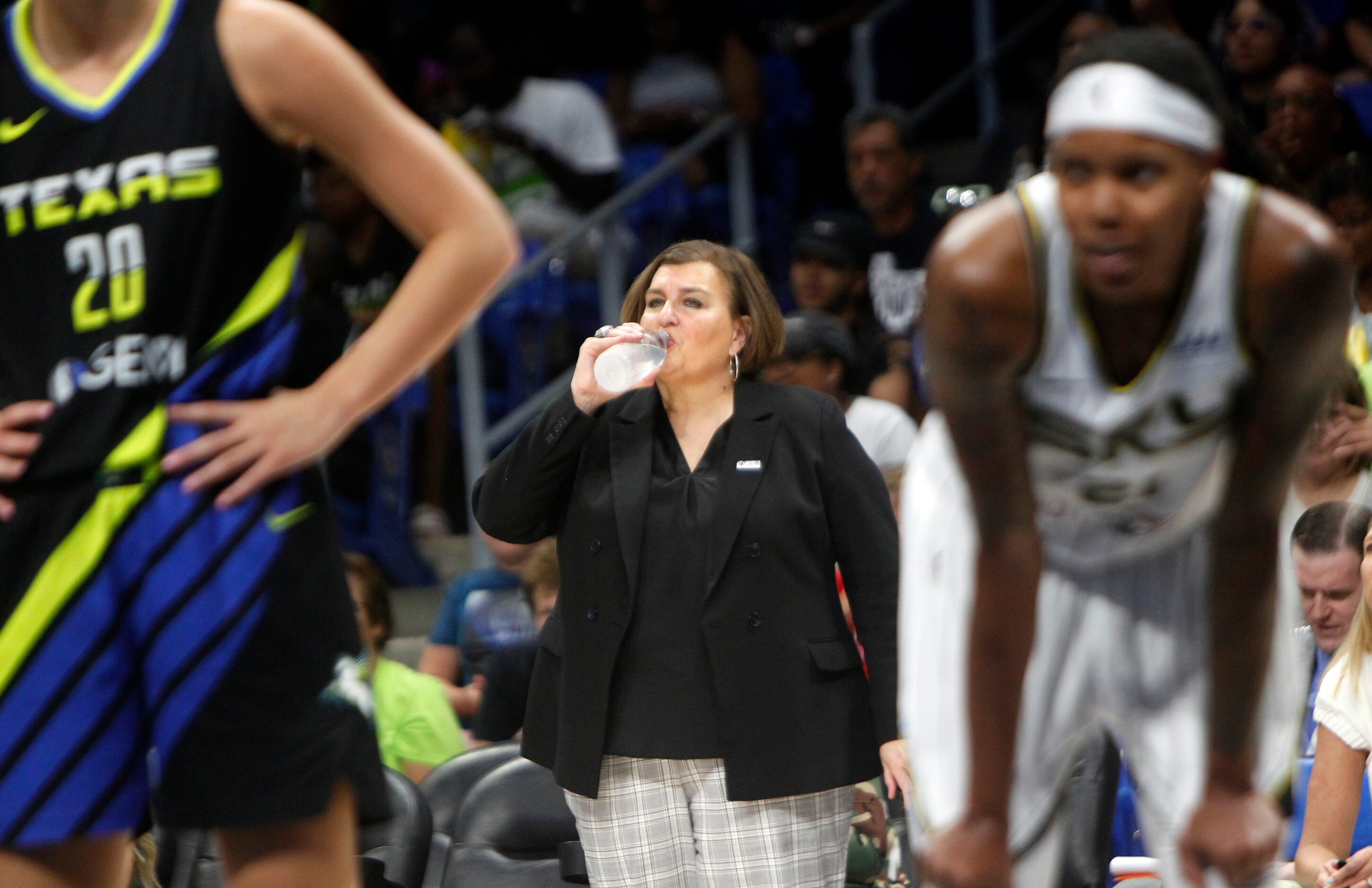 Dallas Wings head coach Latricia Trammell catches a water break as a Wings player prepares...