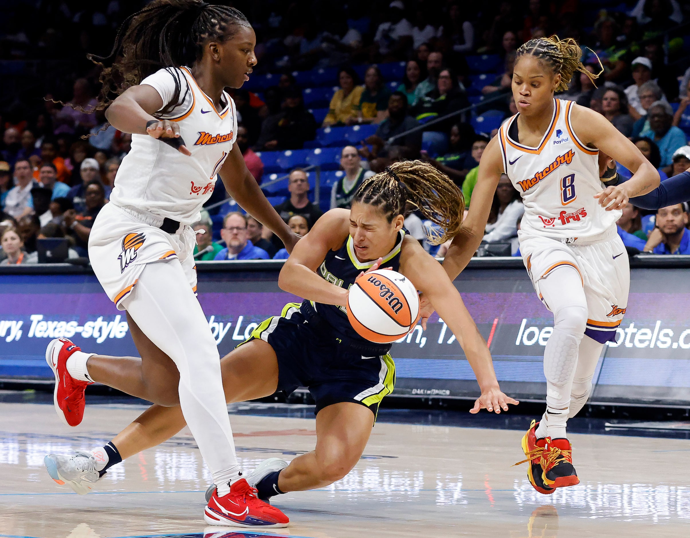 Dallas Wings guard Veronica Burton (12) is tripped up by Phoenix Mercury forward Michaela...