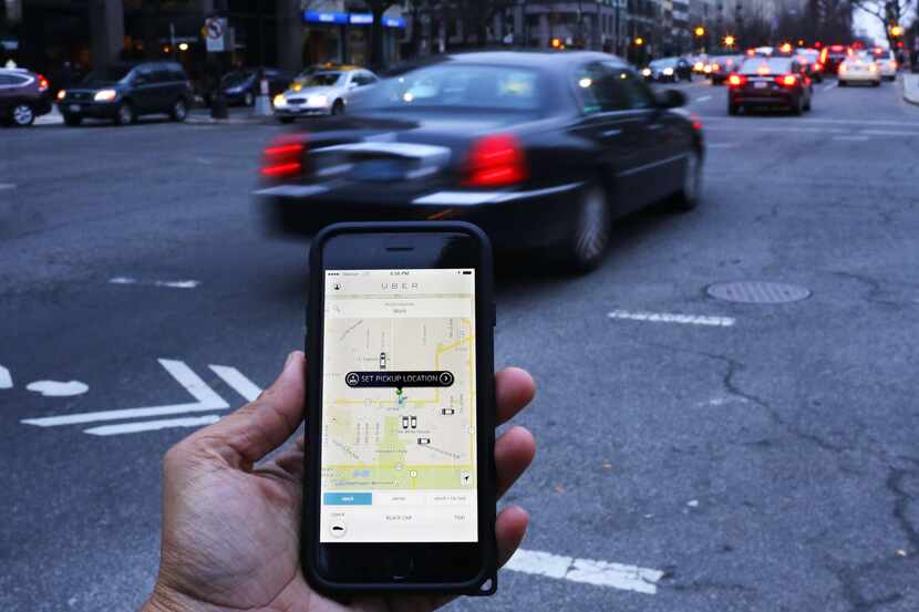 (FILES): This March 25, 2015 file photo shows an UBER application as cars drive by in...
