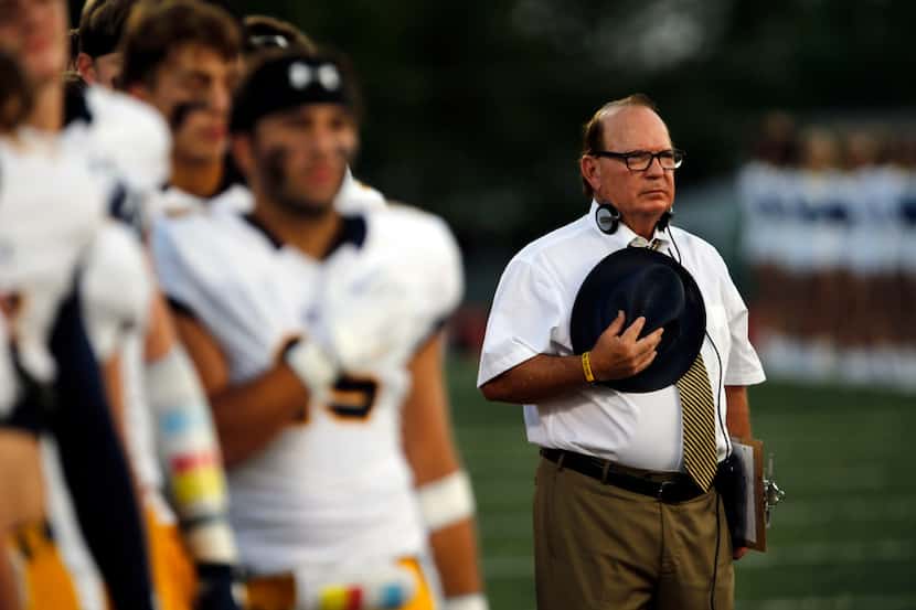 Highland Park coach Randy Allen and his team stand at attention during the national anthum...