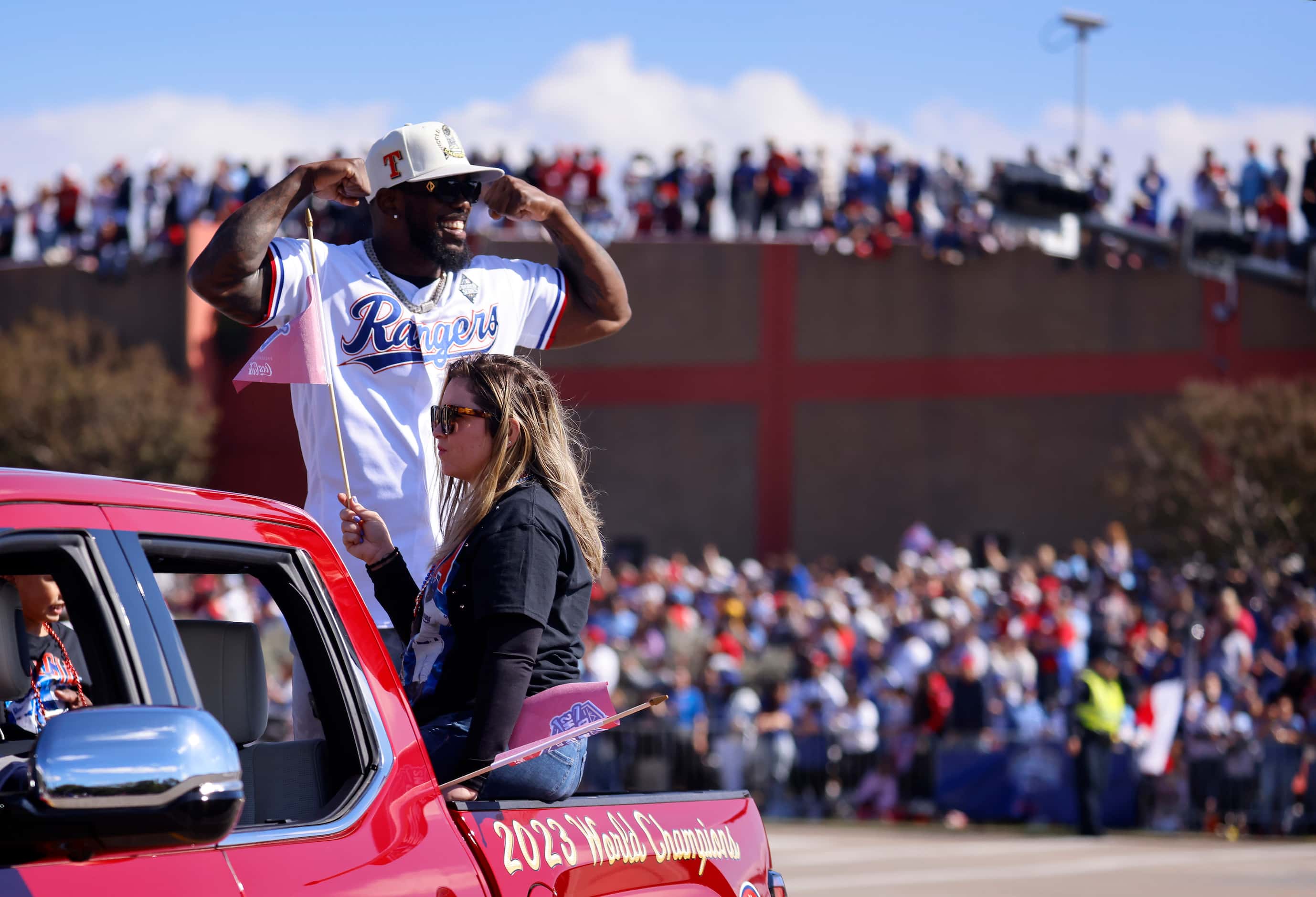 Texas Rangers right fielder Adolis Garcia waves to fans lining the streets and buildings...