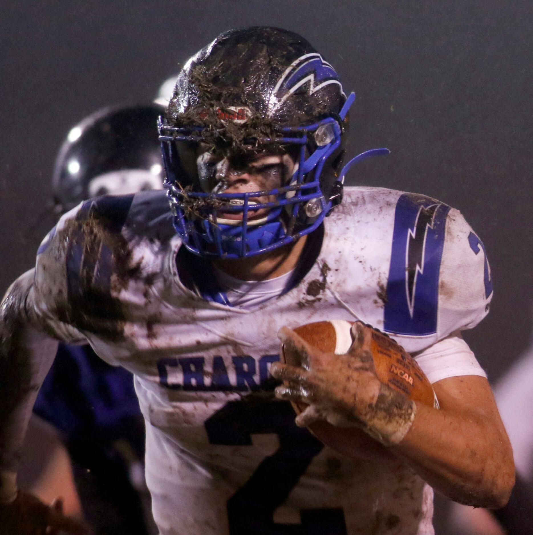 Dallas Christian quarterback Zack Hayland (2) looks through a mask full of grass and mud...