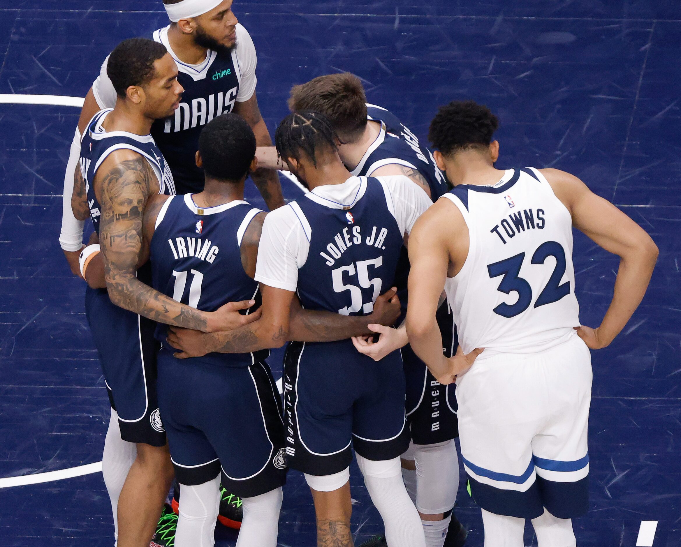 Minnesota Timberwolves center Karl-Anthony Towns (32) leans in to hear the conversation...