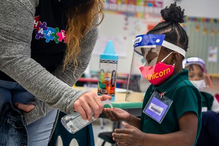 La estudiante de prekínder Jaliyah Webb recibe gel antibacterial antes de ir a la cafetería...