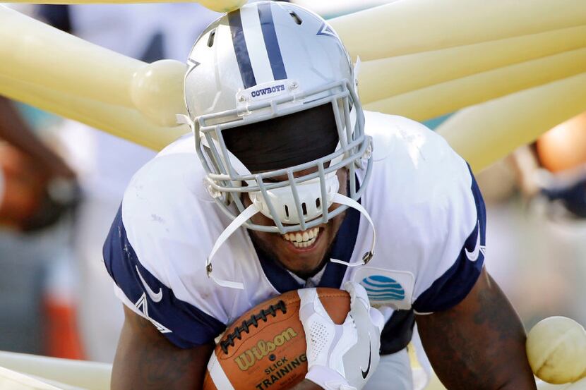 Dallas Cowboys running back Rod Smith's (45) helmet begins to come off as he runs through a...