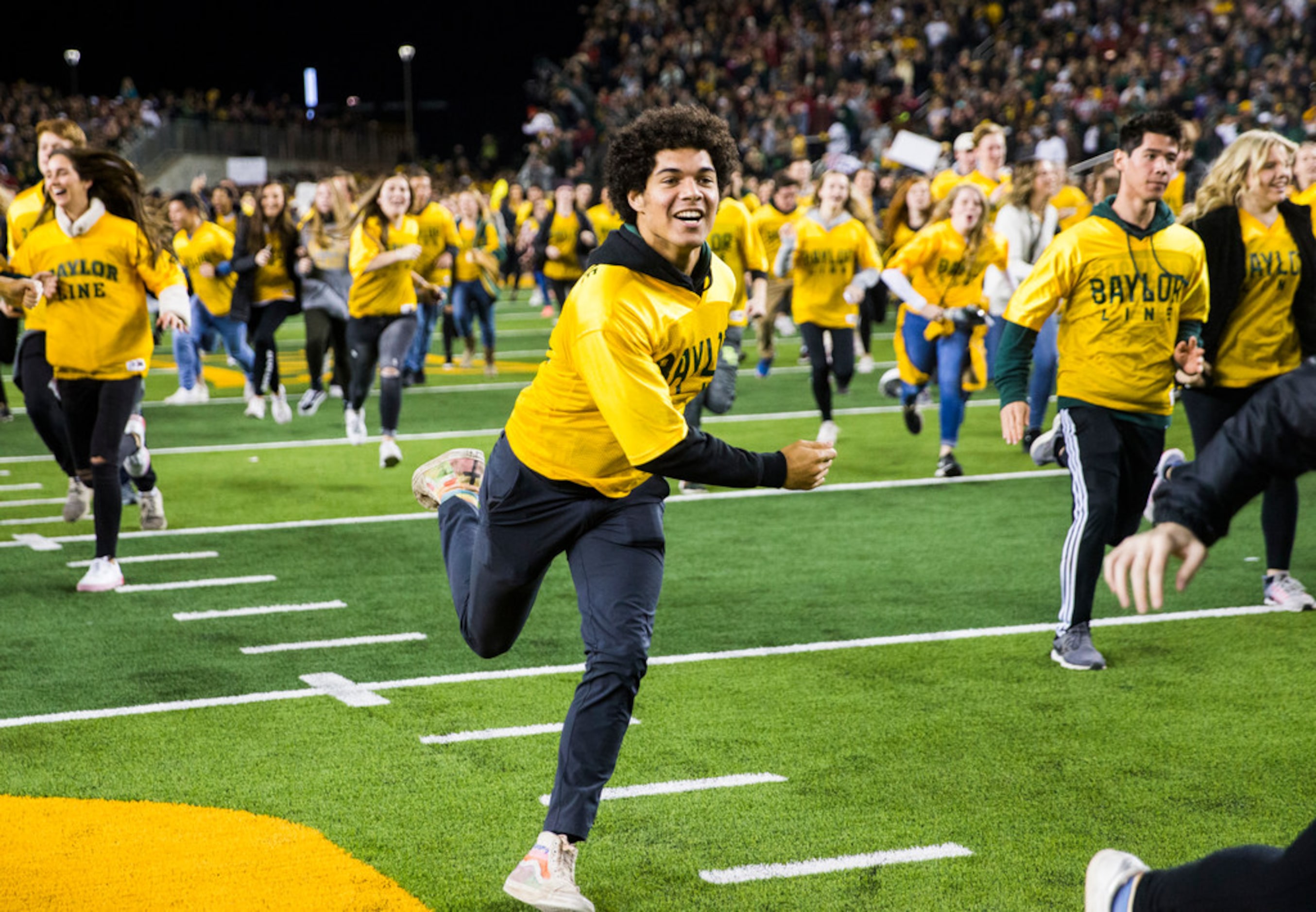 Baylor Bears students run on the field before an NCAA football game between Baylor...