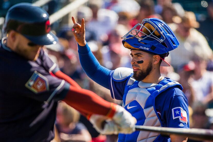 Texas Rangers catcher Robinson Chirinos signals two outs as Cleveland Indians catcher...