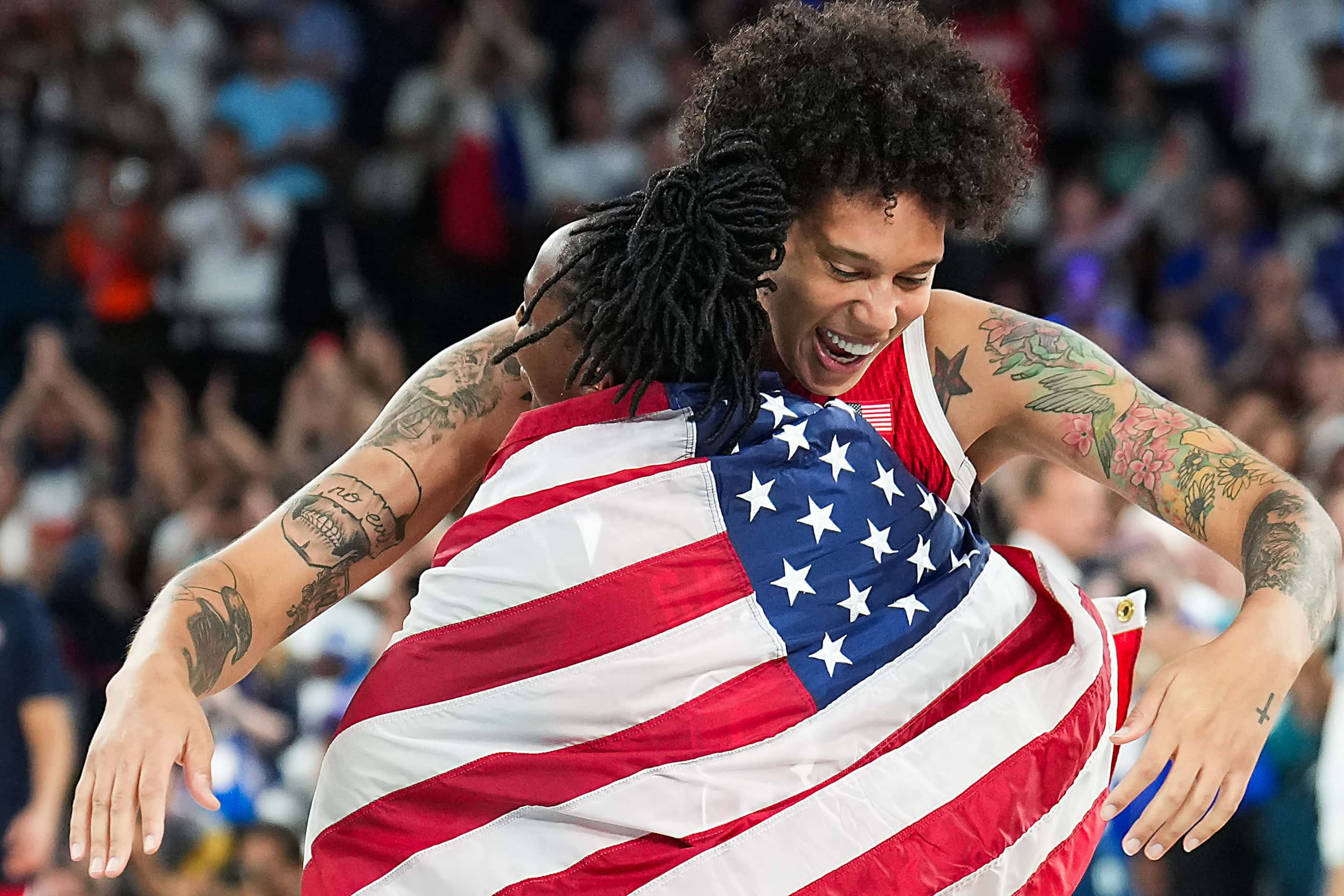 Brittney Griner of the United States hugs Chelsea Gray as they celebrate after a victory...