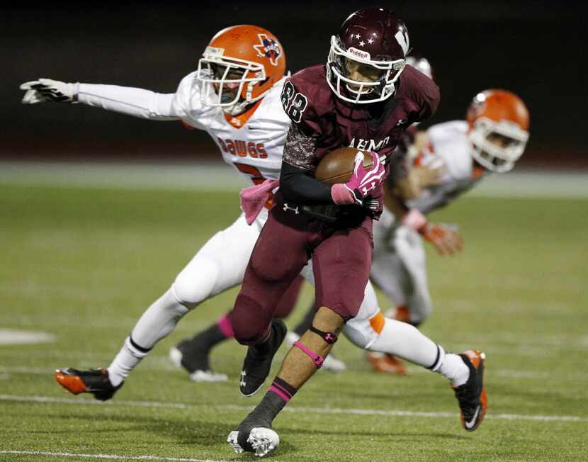 Wylie's Alex Wesley (88) runs a ball past McKinney North's Anthony Grogan (3) during a game...