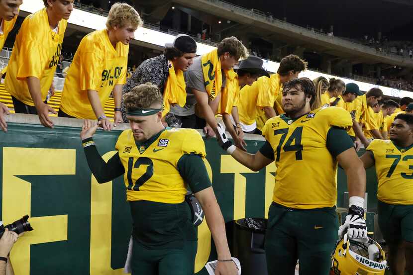 Baylor quarterback Blake Shapen, front left, an lineman Kaden Sieracki shake hands with...