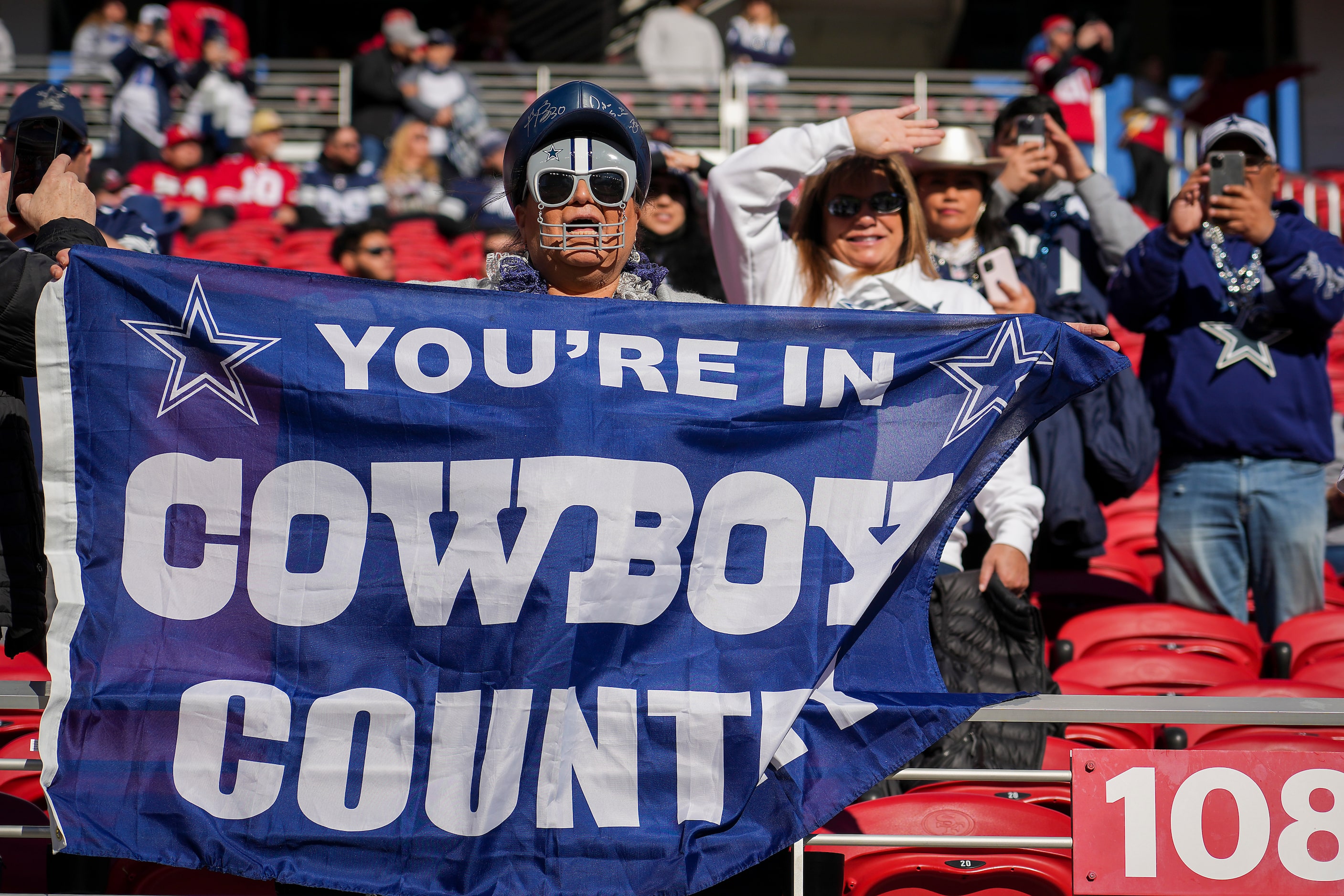 Dallas Cowboys fans cheer their team as the teams warm up before an NFL divisional round...