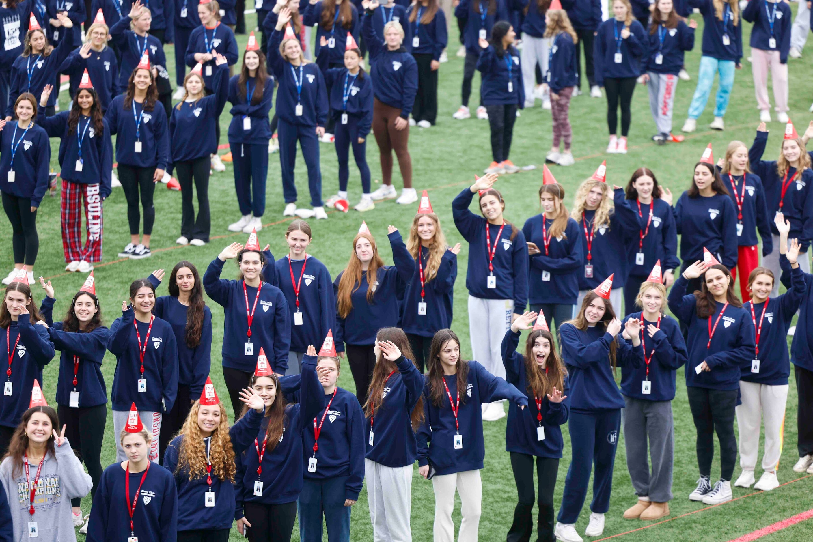 Students wave while standing in formation of "UA 150" for a giant group photo during the...