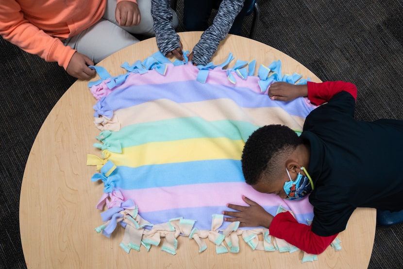 Kinder student Jamere Johnson, 5, lays his head to rest while taking a break from making...