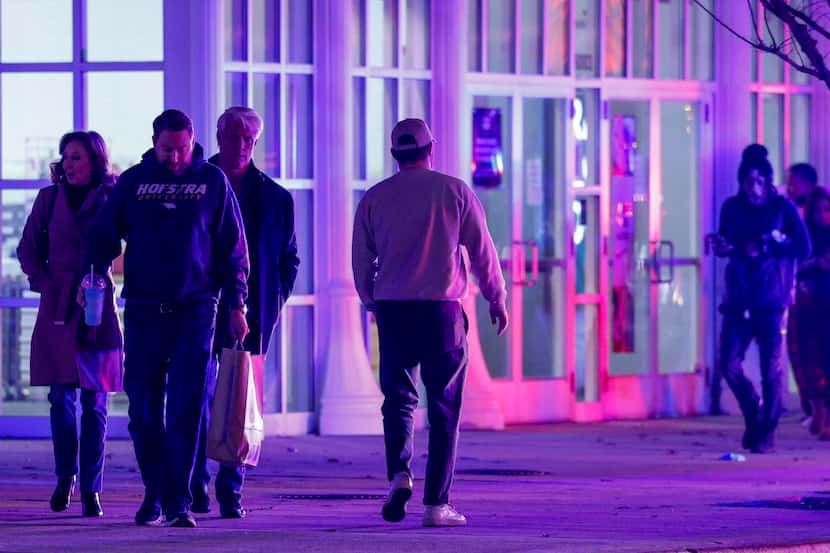 People walk outside after two people were wounded in a shooting at The Parks Mall at...