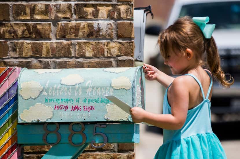 Aviana Ragan, 4, places a letter in a handmade mailbox in honor of her younger sister.