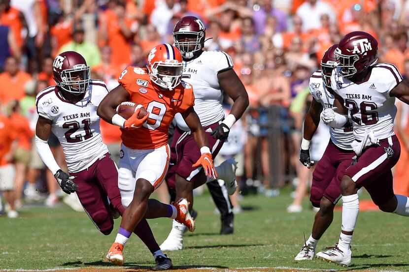 Clemson's Travis Etienne (9) rushes while defended by Texas A&M's Charles Oliver (21) and...