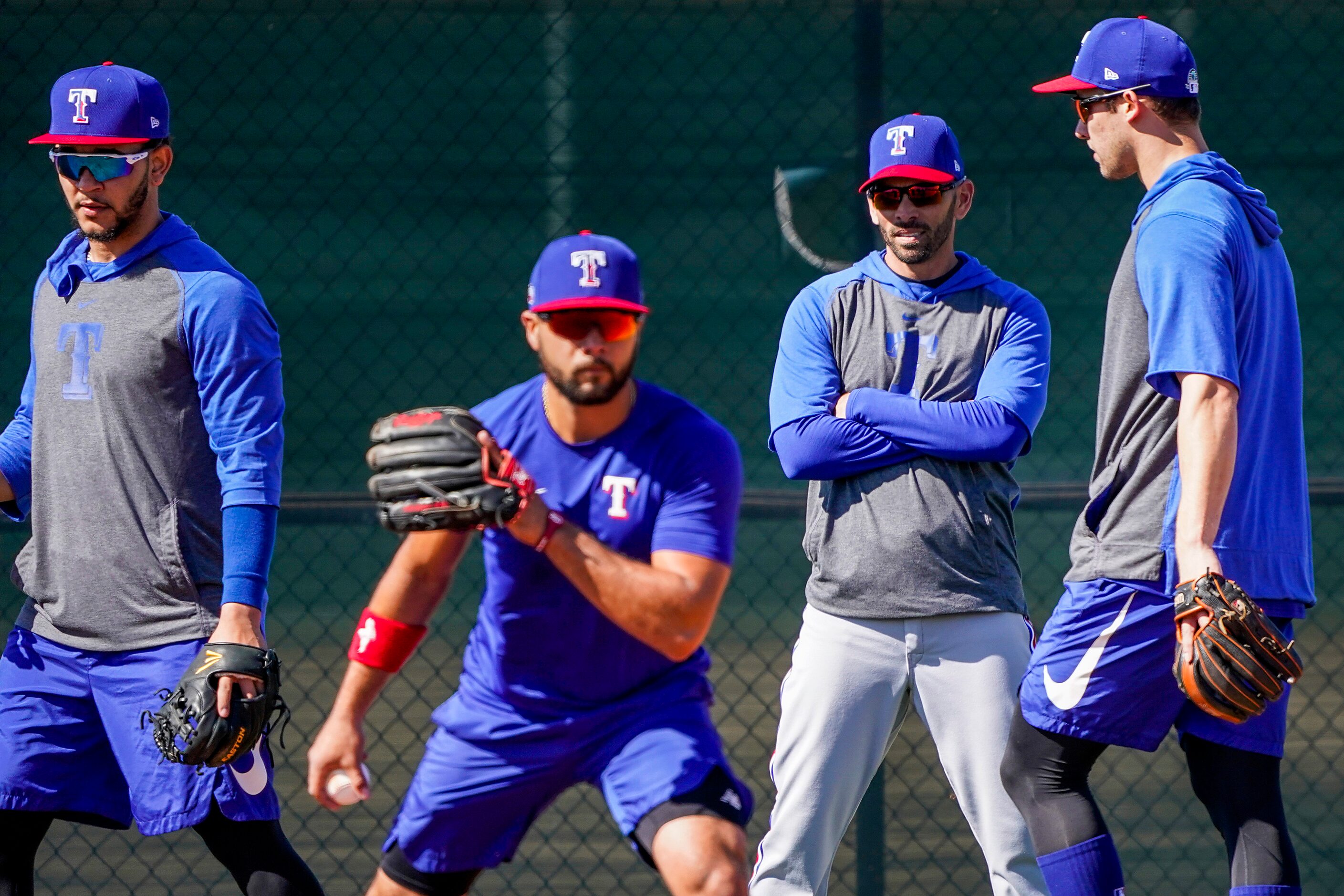 Texas Rangers manager Chris Woodward watches infielders, including Isiah Kiner-Falefa...