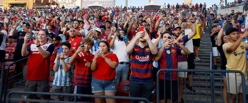 Fans of Inter Miami’s Lionel Messi cheer and record for him as he takes the pitch for...