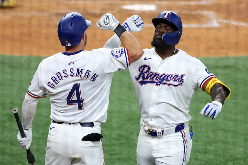 Texas Rangers Robbie Grossman (4) celebrates the home run by Adolis Garcia, right, against...