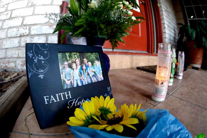 A photograph, flowers and candles are left on the porch where a fatal home shooting took...