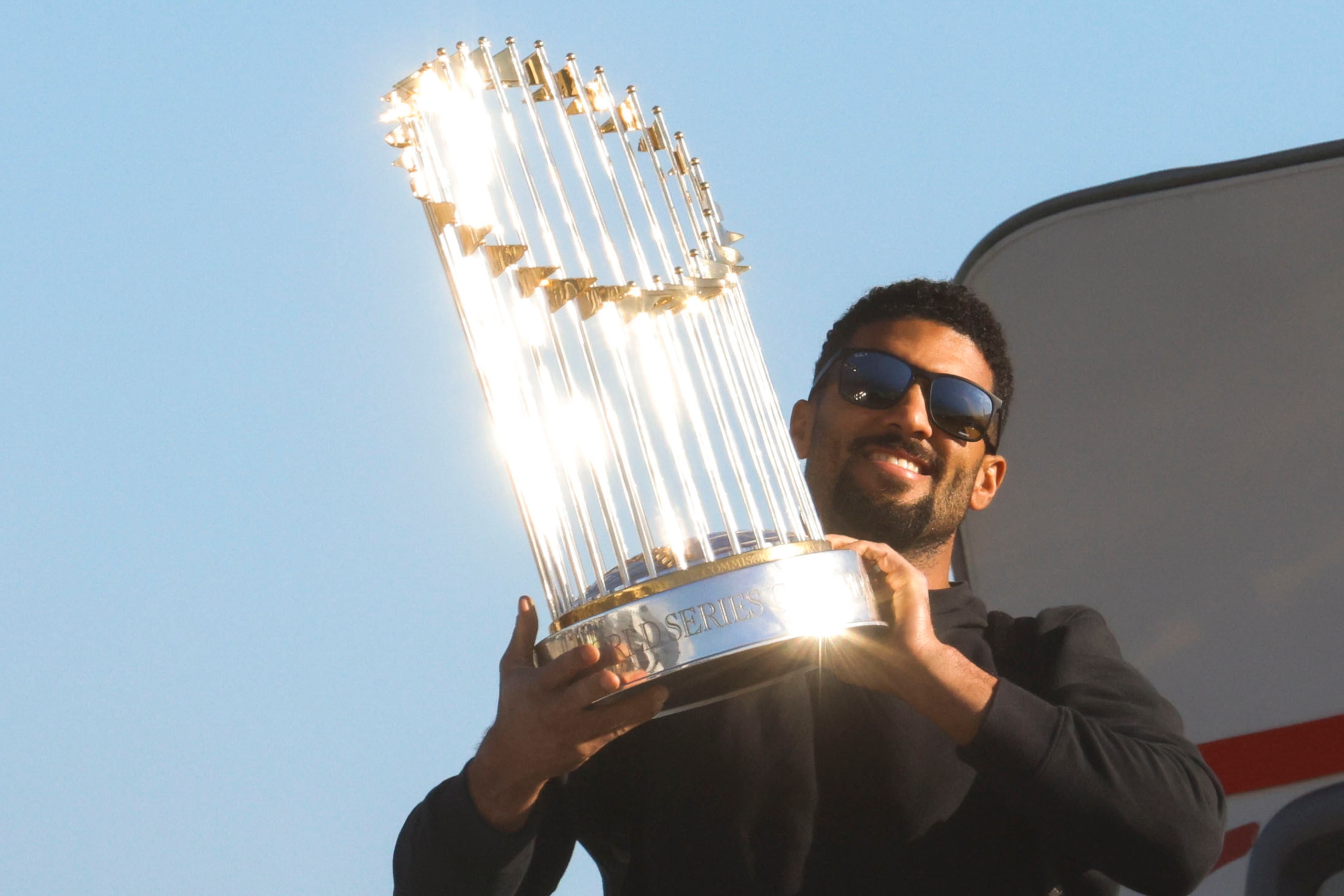 Texas Rangers’ Marcus Semien hoists the Commissioner's Trophy upon the arrival of the team...