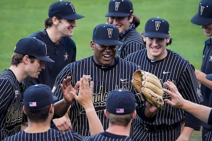 Vanderbilt pitcher Kumar Rocker celebrates with teammates after completing an inning an NCAA...