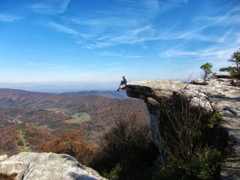 An Appalachian Trail hiker rests on a rocky outcropping on McAfee's Knob, from which you can...