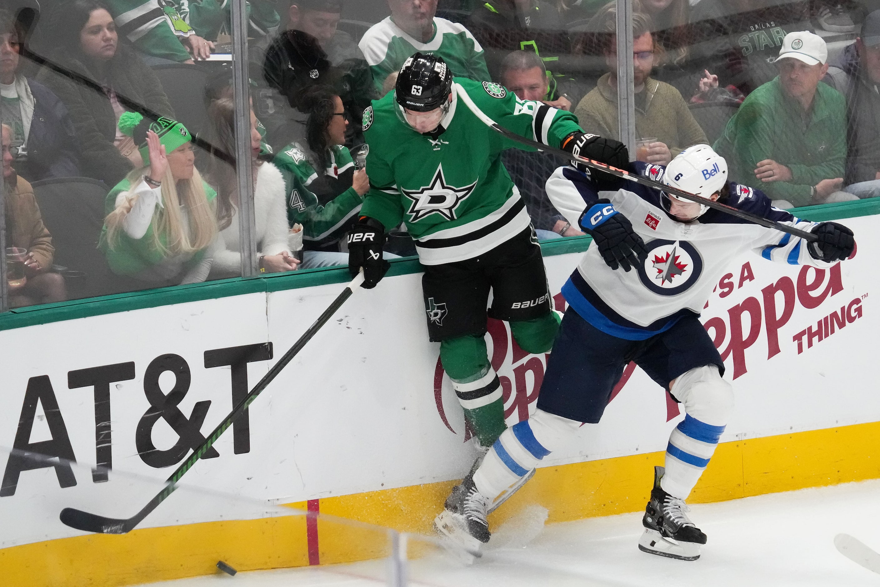 Dallas Stars right wing Evgenii Dadonov (63) fights for the puck with Winnipeg Jets...