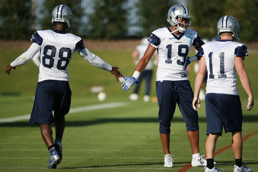 Dallas Cowboys wide receiver Dez Bryant (88) greets wide receiver Brice Butler (19) during...