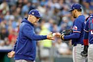 Texas Rangers starting pitcher Dane Dunning, right, hands the ball to manager Bruce Bochy as...