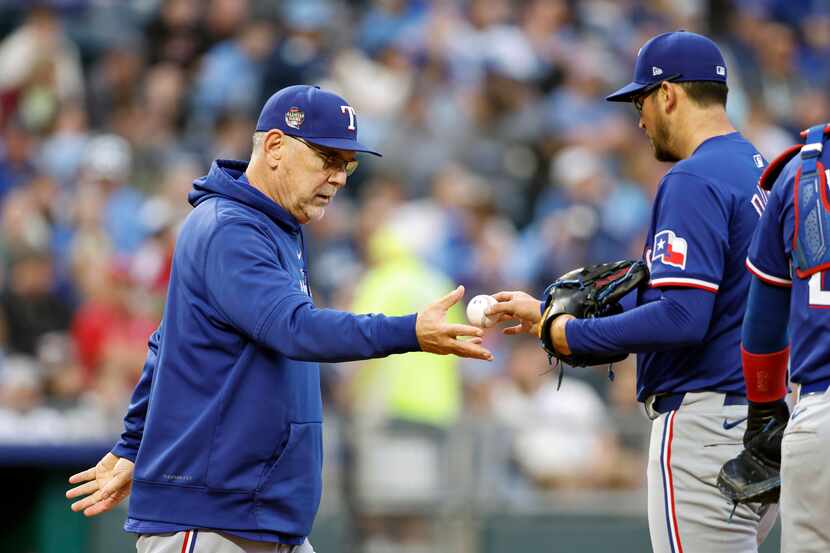 Texas Rangers starting pitcher Dane Dunning, right, hands the ball to manager Bruce Bochy as...