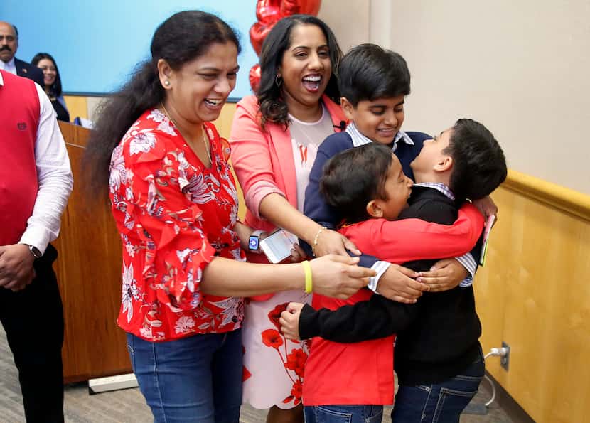 Bone marrow recipient Akshaj Nagilla (in red shirt, right) joins a group hug with his donor,...