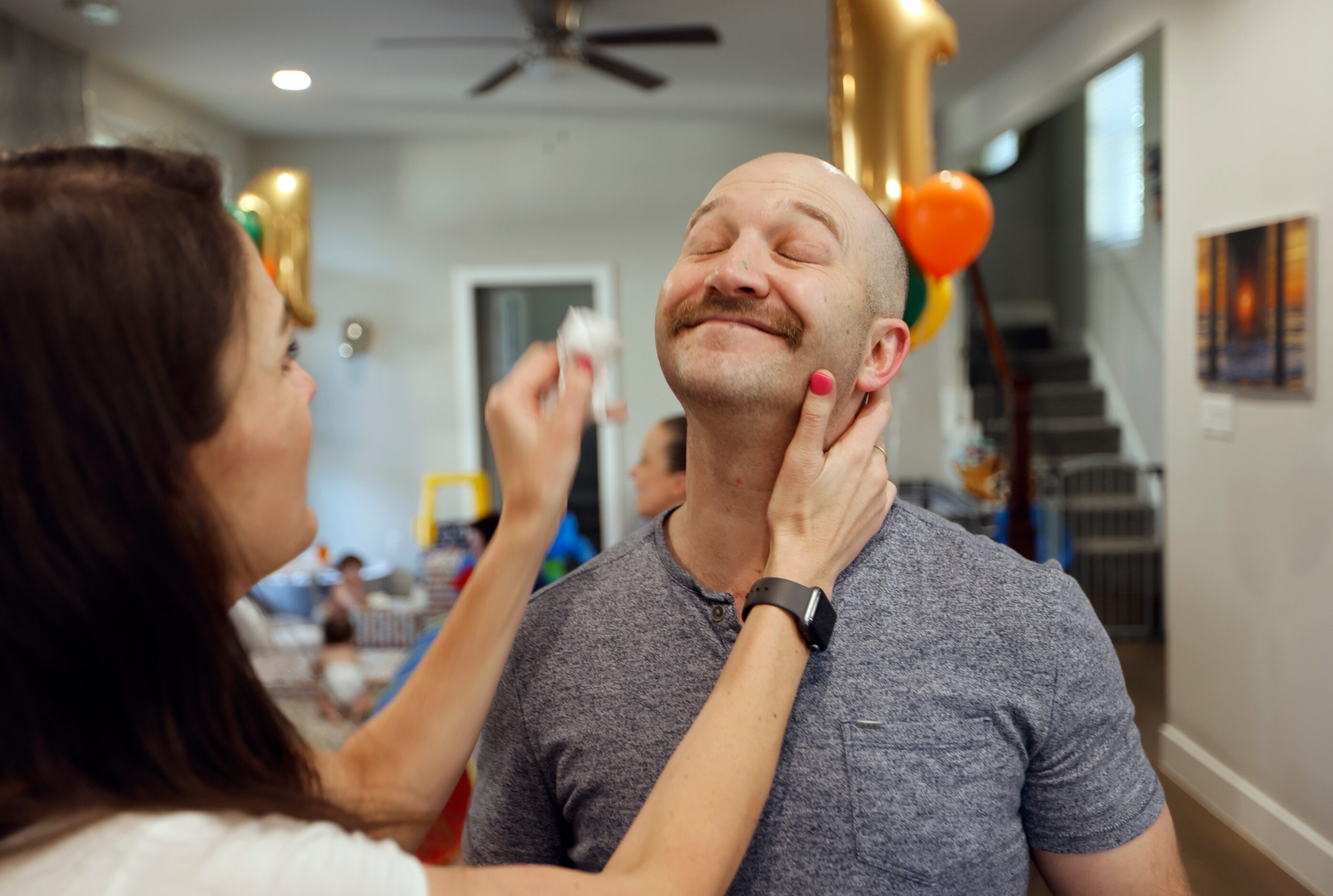 Jenny Marr wipes icing off the face of Chris Marr during their kid's one year birthday party...