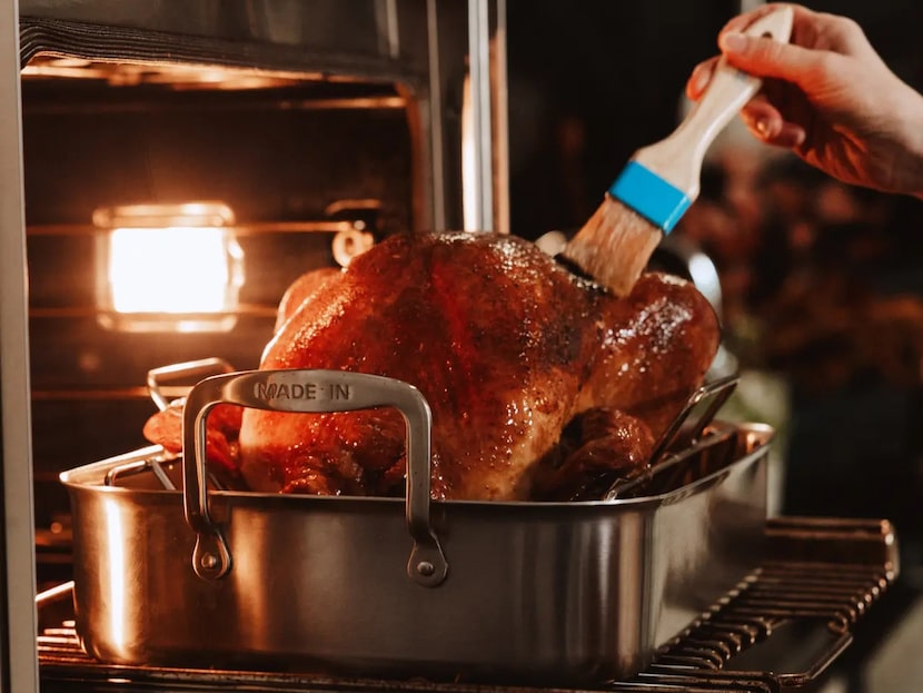 Turkey in oven in stainless steel roasting pan