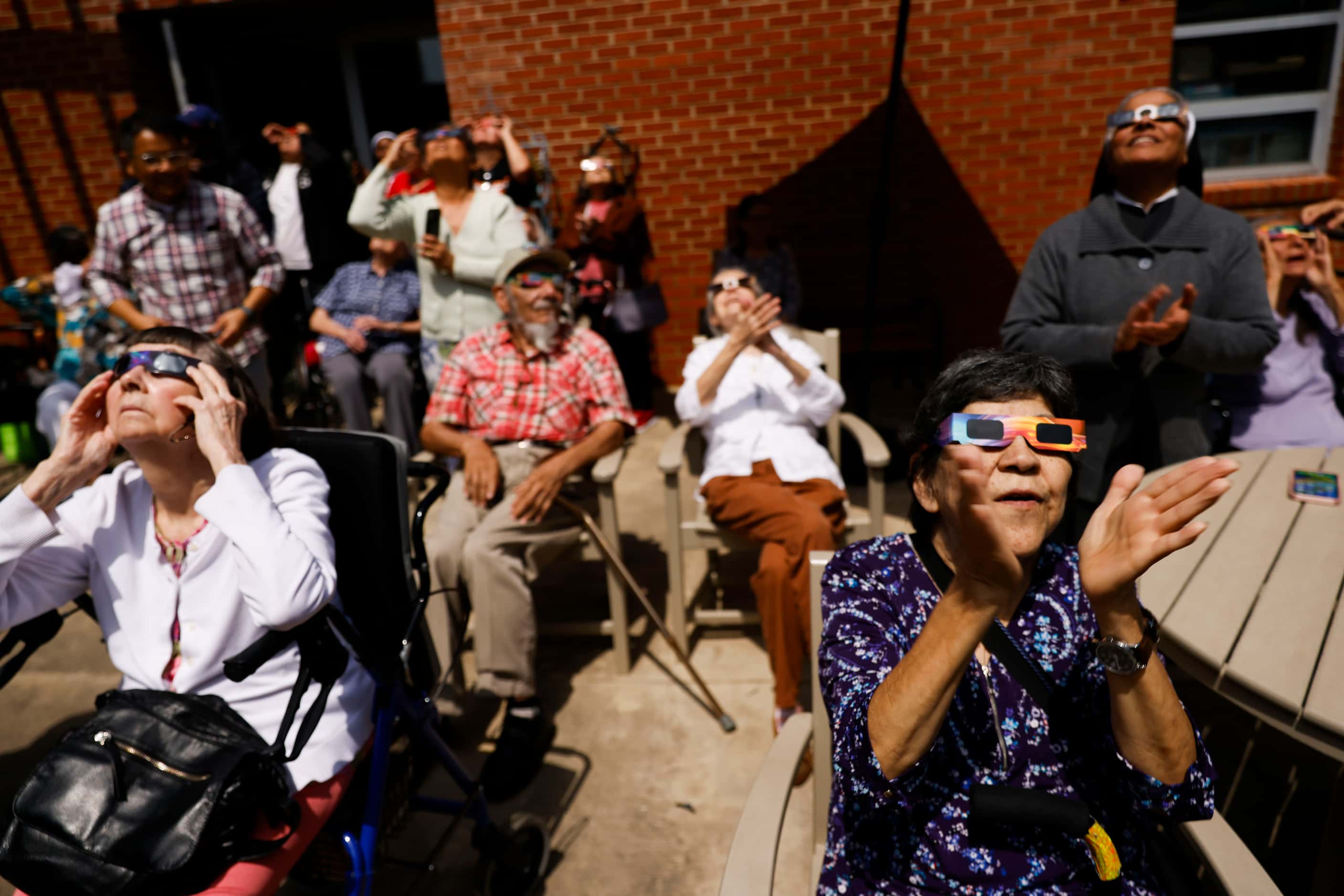 St Joseph's Residence Inc. resident Gloria Perry (right) reacts following the totality of...