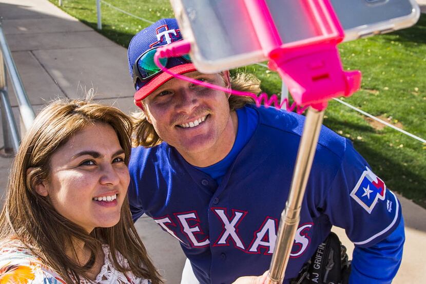 Texas Rangers pitcher A.J. Griffin poses with a selfie with fan Adriana Guerrero after a...