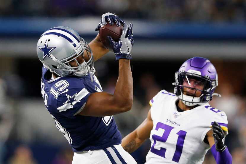 El receptor de los Dallas Cowboys, Amari Cooper (19), atrapa el balón durante un juego...