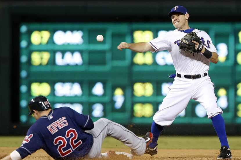 Texas Rangers second baseman Ian Kinsler (5) turns a double play getting Cleveland Indians...