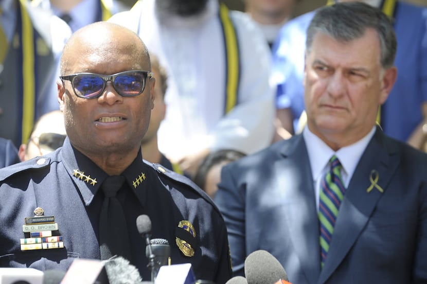 Dallas mayor Mike Rawlings listens as Dallas Police Chief David Brown talks during a prayer...